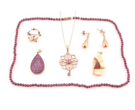A 9ct yellow gold Art Nouveau pendant, the openwork quatrefoil mount set with two pink tourmalines, suspended on a 9ct yellow