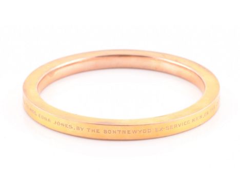 An early 20th century 9ct yellow gold hollow bangle, the bracelet bearing personalised inscription: 'Presented to Miss Edna J
