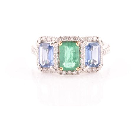 An 18ct white gold, diamond, emerald, and sapphire ring, the triple cluster set with a mixed rectangular-cut emerald, and two