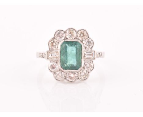 A diamond and emerald cluster cocktail ring, set with an emerald-cut emerald of approximately 1.60 carats, surrounded with ro