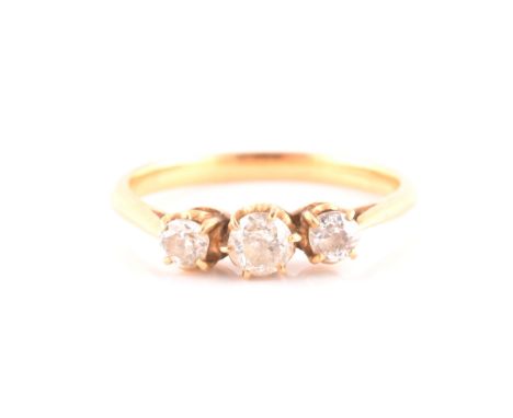 An early 20th century yellow gold and diamond ring, set with three old-cut diamonds, the central diamond measuring approximat