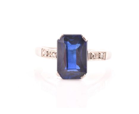 An early 20th century platinum, diamond, and synthetic sapphire ring, set with a mixed rectangular-cut sapphire measuring 10.