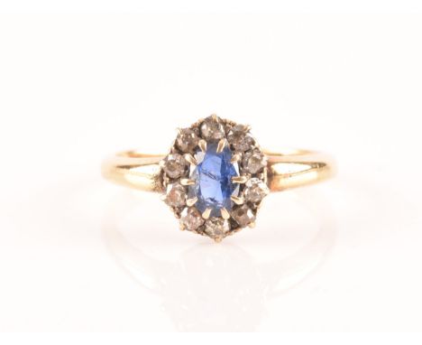 An 18ct yellow gold, diamond, and sapphire cluster ring, set with a mixed oval-cut blue sapphire within a border of old-cut d