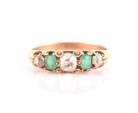 A late 19th / early 20th century diamond and emerald ring, claw-set with three old-cut diamonds and two emeralds, size K 1/2,
