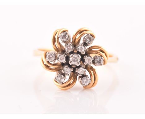 A yellow gold and diamond floral starburst cluster ring, set with thirteen round-cut diamonds, with swirled openwork petal bo