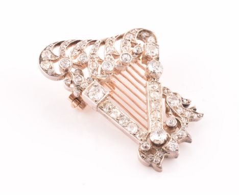 A late 19th / early 20th diamond harp brooch, the scrolled decorative mount inset with mixed old-cut diamonds, within shaped 