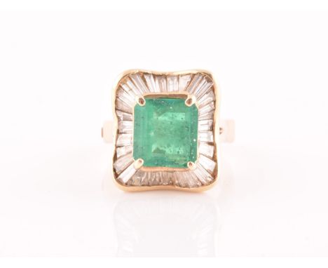 An 18ct yellow gold, diamond, and emerald 'ballerina' cocktail ring, the waved mount inset with tapered baguette-cut diamonds