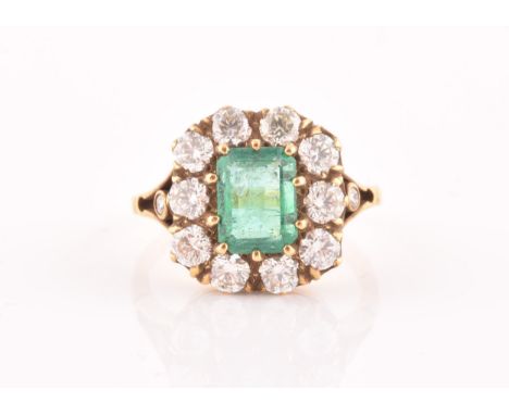 An 18ct yellow gold, diamond, and emerald ring, centred with a mixed emerald-cut emerald of approximately 1.50 carats, surrou