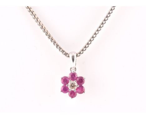 An 18ct white gold, diamond, and ruby floral cluster pendant, centred with a round brilliant-cut diamond of approximately 0.1