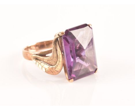 A 14k yellow gold and synthetic corundum ring, the Alexandrite style stone in a mixed fancy rectangular cut, four claw set, t