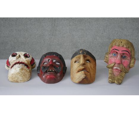 A collection of four vintage carved and painted masks including a skull and a devil. H.26 W.18 D.11CM (largest) 
