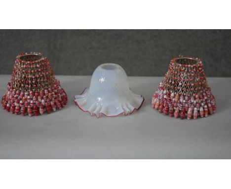 A pair of red and white beaded lampshades along with an opal and cranberry glass ruffled edge lampshade. H.12 D.14 