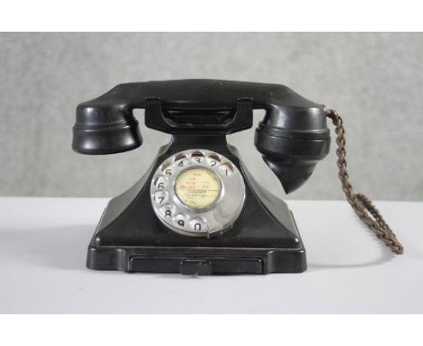 A GPO vintage 1920's black bakelite dial telephone marked 1/232CB, FWR 59/2, with pull out directory drawer. 