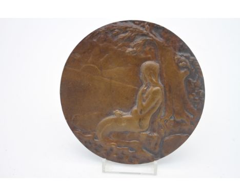 An Art Nouveau style bronze relief plaque depicting a mermaid on a rock under a tree gazing at a sunset. Diameter: 13cm. 