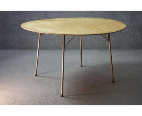 A mid century vintage Heal's dining table on metal supports with maker's label to the underside. H.70 Diameter.120 cm. 