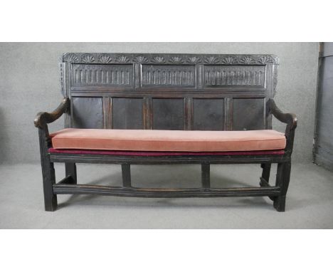 A 17th century oak hall bench with carved and panelled back above fitted pad cushion on square stretchered supports. H.118 W.
