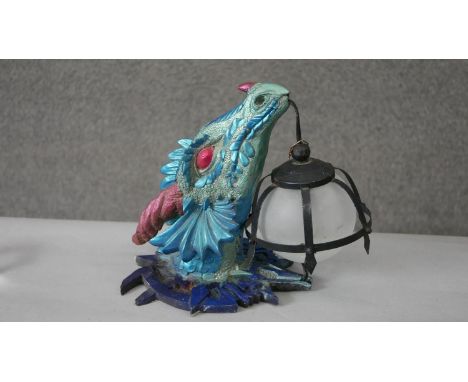 A metallic painted resin dragon head wall lamp with caged frosted glass globe shade. H.30 W.36cm 