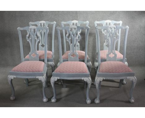 A set of six painted Chippendale style dining chairs with carved and pierced splat backs above drop in seats on carved cabrio