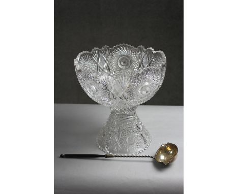 A large early 20th century hand cut crystal punch bowl and stand with star design along with a turned horn handled silver pun