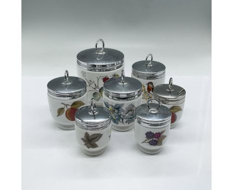 Collection of white porcelain oven-safe egg cups adorned with delicate floral, fruit, and bird designs. Each has a silvertone