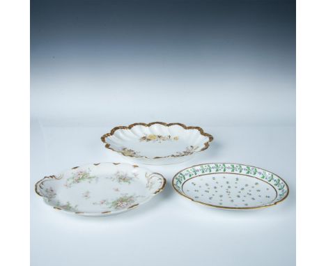 A white oval platter with green foliage and blue dandelions, a round white platter with pink floral bouquets and gold accents