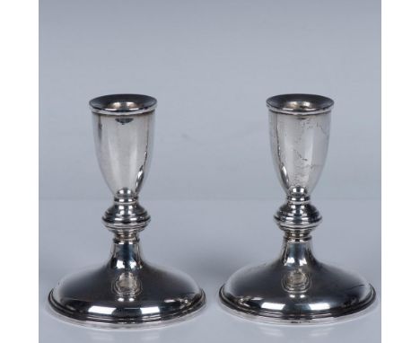 A set of two unadorned candleholders. Cartier Sterling Weighted 119 impressed on the underside. Weight total of 1 candlestick