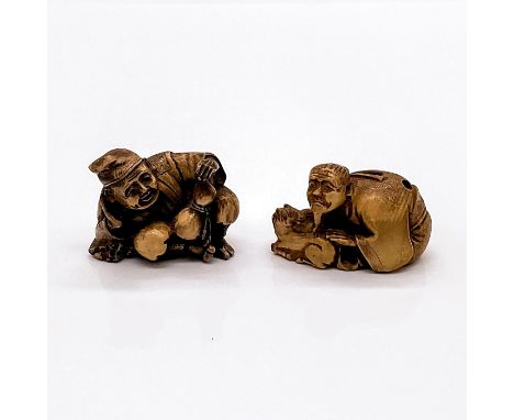 Two carved figures in imitation of a Japanese netsuke. One figure is a man holding a calabash, and other man is holding a sma