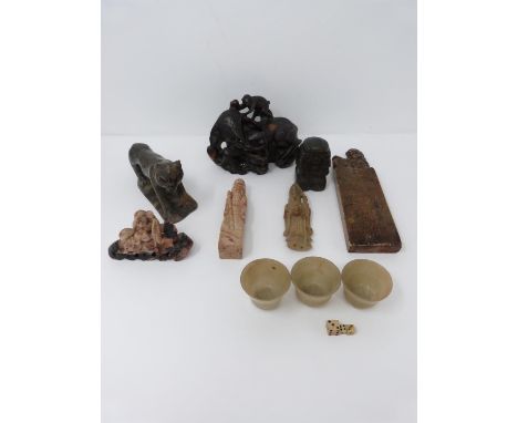 A collection of Chinese soapstone and other items. Including a brass weight in the form of a boy, three soapstone dice cups, 