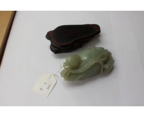 A Chinese Qing dynasty celadon jade of a seated duck, carved with a wheatsheaf in its beak with duckling to side, approx 6cms