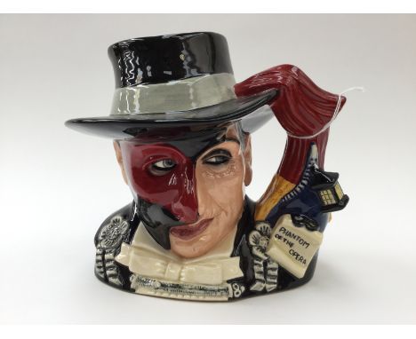 A Royal Doulton character jug depicting The Phantom of the Opera D7017 , handle modelled after a theatre curtain and coach li