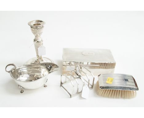 A George VI silver cigarette box, Birmingham 1937, an Edwardian silver weighted candlestick, London 1906, a silver backed clo