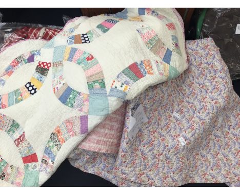 A Welsh wholecloth quilt 1930s in red, blue and beige floral fabric with a printed cotton pale pink backing, hand quilted. An