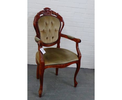 A contemporary stained wood open armchair with carved top rail over upholstered button back, arms and seat, 104 x 56cm