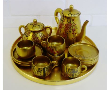 A Japanese gold lacquered tea set comprising six cups, six saucers, sugar bowl, teapot and circular tray, (15) 