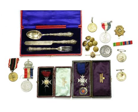 A silver three piece knife, fork and spoon set, cased, two silver cricket medals, cartwheel penny, coronation medals, militar