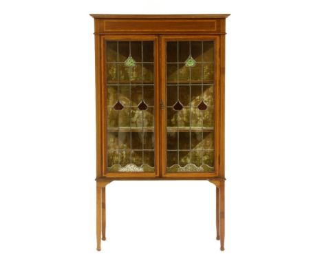 An Edwardian mahogany and crossbanded display cabinet, enclosed by a pair of leaded light glazed doors, 89cm wide, 36.5cm dee