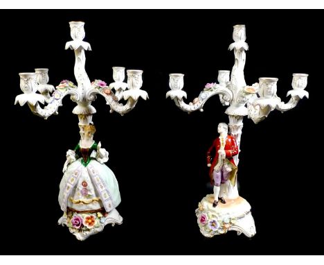 A pair of Schierholz Plaue, PMP porcelain figural candelabra, each with four scroll arms, above a Gentleman, the other a Lady
