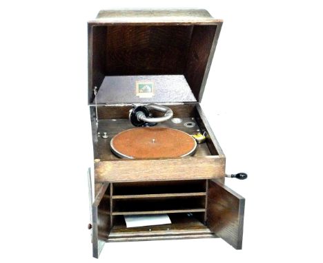 An Edwardian His Master Voice oak cased gramophone, caddy form lift lid opening to reveal the turntable, twin doors to front,