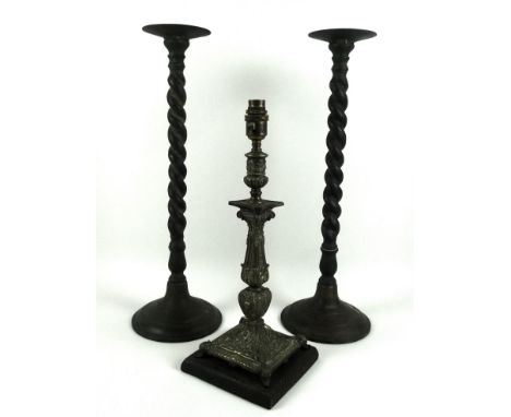 A pair of tall bronzed brass candle sconces, each with a spiked saucer above barley twist columns on a spreading circular bas