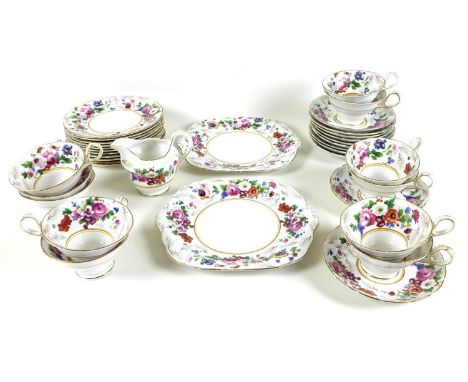 An early 20th century part tea service decorated with roses and garden flowers with gilded highlights, cups and jug marked wi