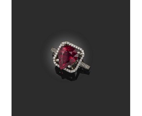 A tourmaline and diamond cluster ring, the pear-shaped tourmaline set within square-shaped diamond surround and diamond shoul