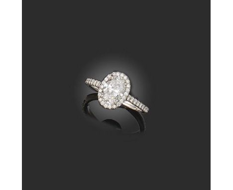 Tiffany & Co, a diamond cluster ring, the oval-shaped diamond weighing 1.10cts, within a diamond surround and further diamond
