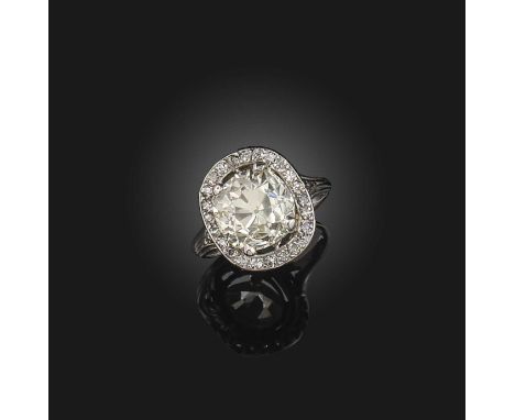 A diamond cluster ring, set with a central old cushion-shaped diamond weighing 4.95cts within a border of diamonds in platinu