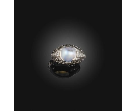 A moonstone and diamond ring, claw-set with a cabochon moonstone, to an openwork band set with cushion-shaped diamonds, mount