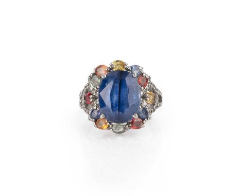 A kyanite, sapphire and diamond ring, claw-set with an oval kyanite weighing 10.70 carats, to a silver mount set with multico