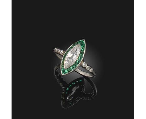 An Art Deco emerald and diamond ring, set with a central marquise-shaped diamond within calibre-cut emerald surround and diam