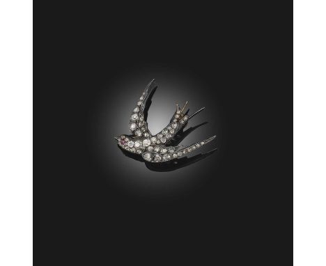 A diamond brooch, late 19th century, designed as a swallow in flight, set with cushion-shaped and rose-cut diamonds, its eye 