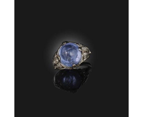 A cabochon sapphire and diamond ring, the pale blue sapphire set within diamond surround in white gold, size N