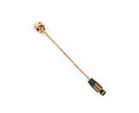 A ruby-set gold stickpin, designed as a skull in yellow gold, 6.3cm, case