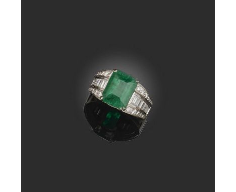 An emerald and diamond ring, claw-set with a step-cut emerald weighing 5.41 carats, to a mount channel-set with baguette diam